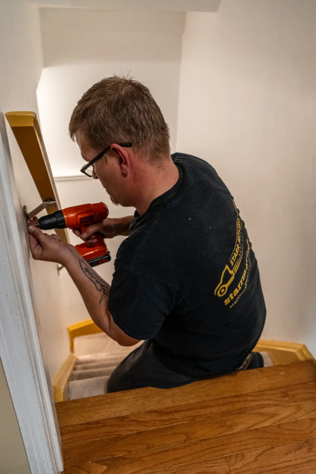 man-installing-stair-railing-with-drill