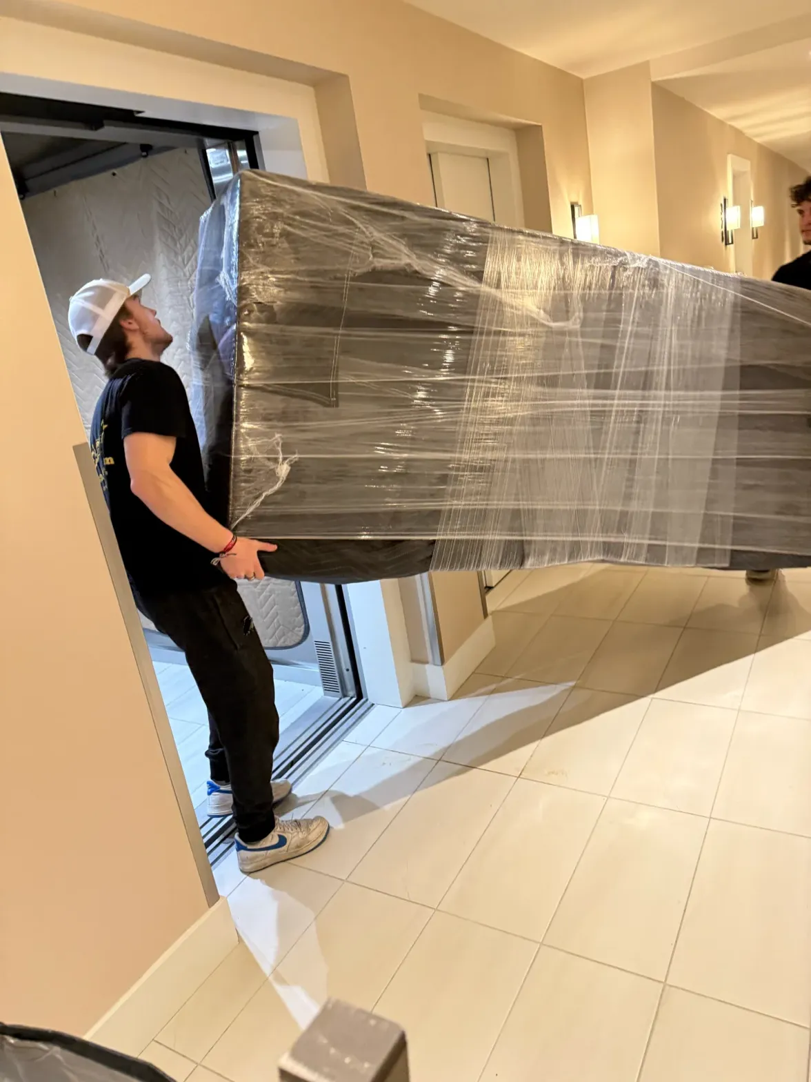 movers-carrying-wrapped-furniture-through-doorway